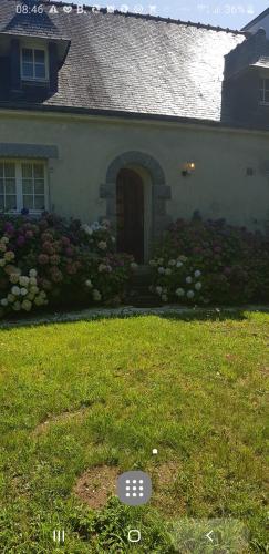 Ein Haus mit einem Blumenstrauß im Hof. in der Unterkunft Lieu dit kerleo in Melgven