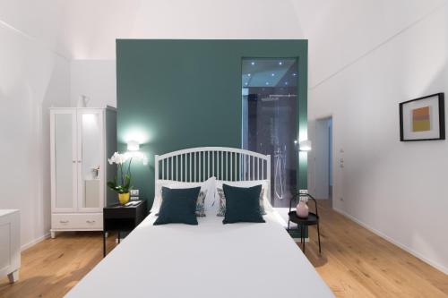 1 dormitorio con cama blanca y pared azul en I Colori della Puglia Rooms, en Trani