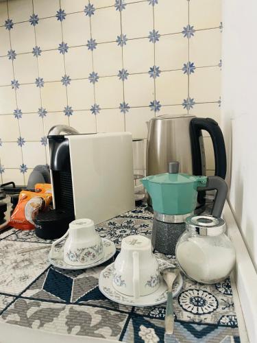 un piano di lavoro con macchinetta del caffè e bollitore per il tè di La casa sulla piazza (Historic apartment) a Enna