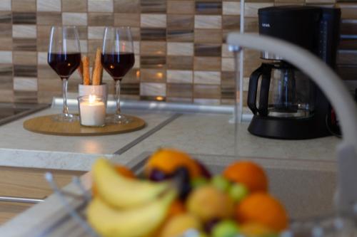 two glasses of wine and fruit on a kitchen counter at Maistro Suites with pool, Matala in Matala