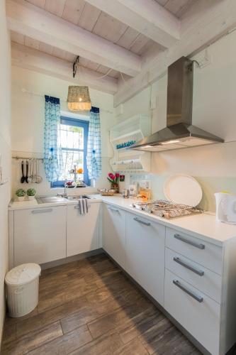 a kitchen with white cabinets and a sink at Cascina Arcangelo Raffaele in Verduno