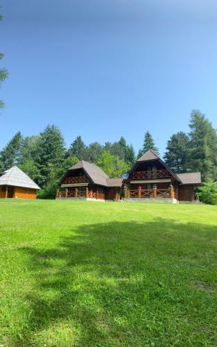a large building in the middle of a green field at Brvnare Park Borova in Zlatibor