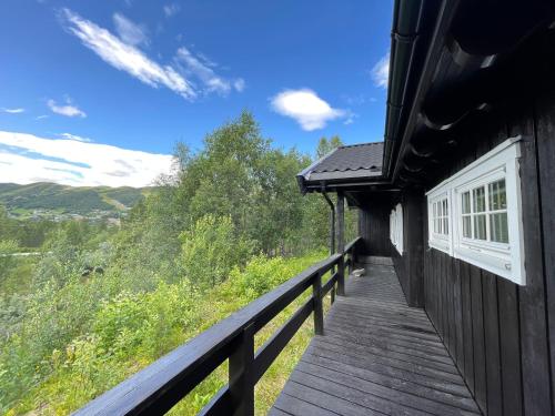 - une terrasse en bois sur le côté d'une maison dans l'établissement Baybu - cabin close Geilo Skisenter and the center of Geilo, à Geilo