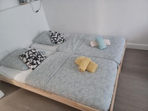 a bed with pillows on it in a room at Pratique Porte de la villette Beau Studio Spacieux in Aubervilliers