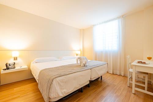ein Schlafzimmer mit einem großen Bett und einem Fenster in der Unterkunft Hotel Rosella affiliated by Intelier in Sa Coma