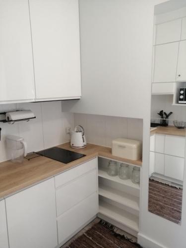 a kitchen with white cabinets and a counter top at Apartament w centrum in Lublin