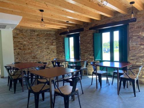 um restaurante com mesas e cadeiras de madeira e janelas em O TEU SITIO em Ribadeo