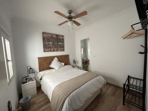 a bedroom with a bed with a ceiling fan at Las Brisas Estepona in Estepona