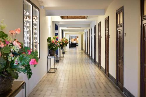 un pasillo de un edificio con flores y plantas en Van der Valk Hotel Mechelen, en Malinas