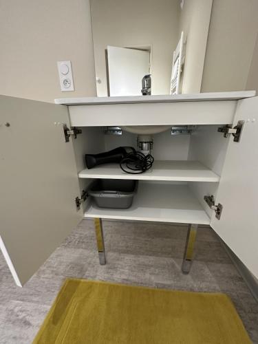 a shelf in a room with a sink and a mirror at L'Entrepotes in Rethel