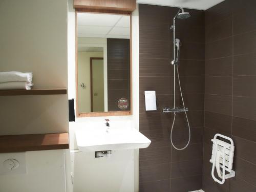 a bathroom with a sink and a shower with a mirror at Campanile Dijon Congrès Clemenceau in Dijon