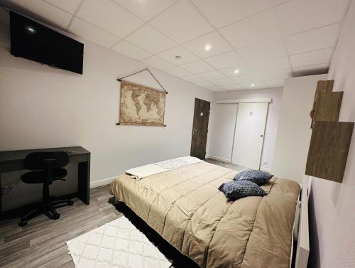 a bedroom with a bed and a desk and a computer at L'Entrepotes in Rethel