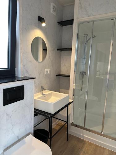 a bathroom with a sink and a shower at Bed & Bike Resort Trzęsacz in Trzęsacz