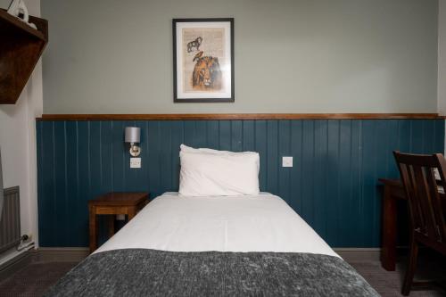 a bed in a room with a blue wall at Cocked Hat by Greene King Inns in Coventry