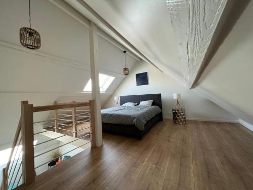 - une chambre mansardée avec un lit et un escalier dans l'établissement Cosy Nest, à Bruxelles