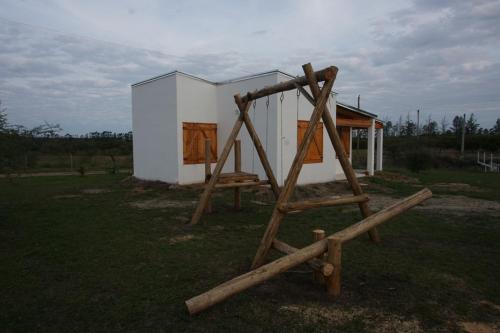 a house with a wooden ladder in front of it at "AGUAPÉ" Alojamiento rural con PILETA in Chajarí