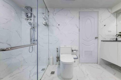 a bathroom with a toilet and a glass shower at Skyline view, Great location, Spacious apartment, in Bangkok