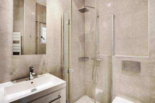 une salle de bain avec douche et lavabo dans l'établissement Pick A Flat's Apartment in Montaigne - Cour Albert 1er, à Paris