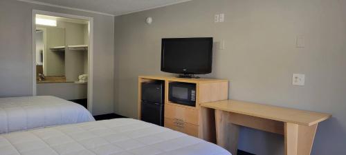 um quarto com uma cama e uma televisão numa cómoda em Superlodge em New Castle