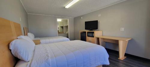 um quarto de hotel com duas camas e uma televisão em Superlodge em New Castle