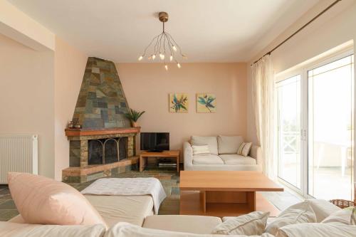 a living room with a couch and a fireplace at Villa Melenia 2 in Agia Pelagia