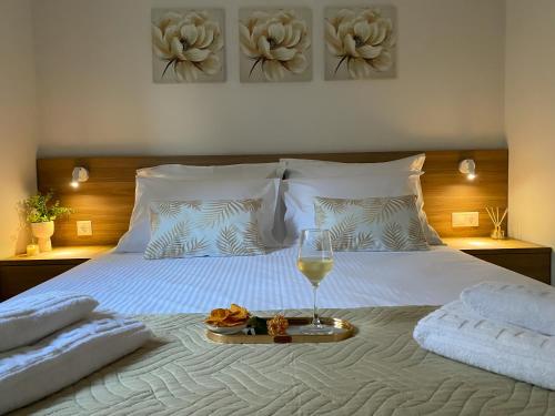 a bed with a plate of food and a glass of wine at Maistro Suites with pool, Matala in Matala
