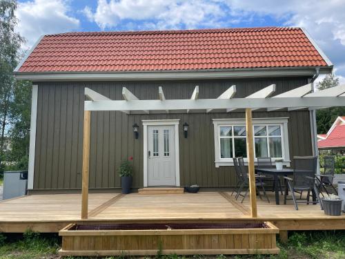 a tiny house with a deck and a table at Ny lägenhet i Vesene in Ljung