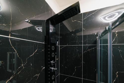 a bathroom with black marble walls and a shower at La dimora delle zite in Naples
