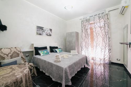 een kamer met een bed, een stoel en een raam bij La dimora delle zite in Napels