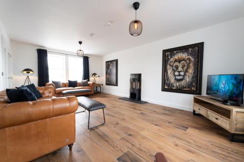 a living room with a couch and a television at Escape Ordinary at Lily's Pad in Enniskillen