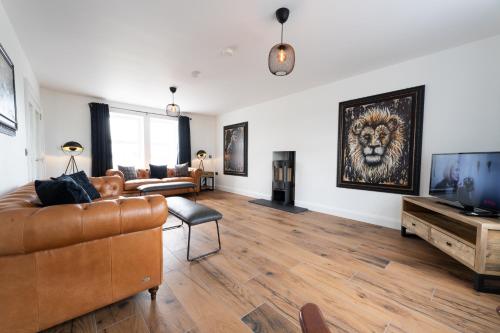 a living room with a couch and a television at Escape Ordinary at Lily's Pad in Enniskillen