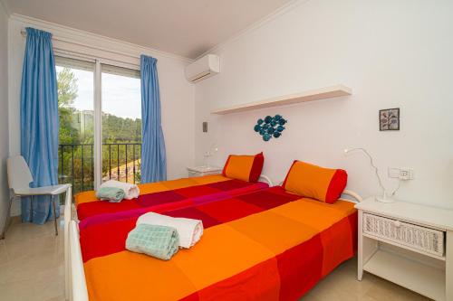 a bedroom with a colorful bed and a balcony at Casa Pianti villa in Altea Hills in Altea