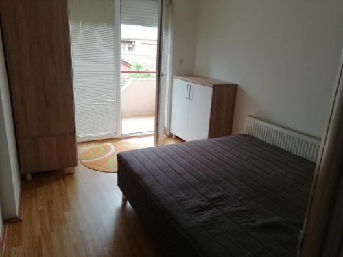 a bedroom with a bed and a refrigerator at One bedroom apartment-Centar in Kavadarci