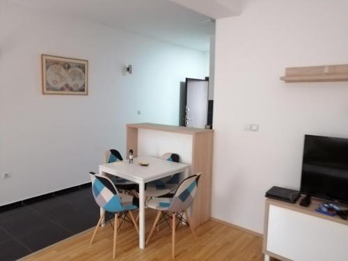 une salle à manger avec une table et des chaises blanches dans l'établissement One bedroom apartment-Centar, à Kavadartsi