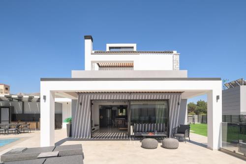una rappresentazione della parte anteriore di una casa con patio di Monti Luxury Villa, Close to South Crete beaches, By ThinkVilla a Lefkogeia