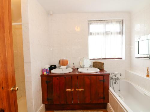 a bathroom with two sinks and a tub at Toberlonagh 
