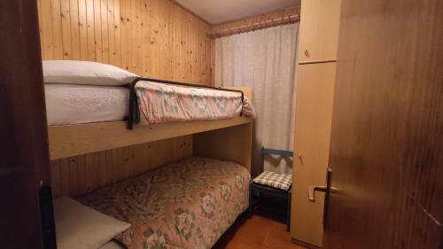 a small bedroom with two bunk beds and a closet at Residence Marmolada in Rocca Pietore
