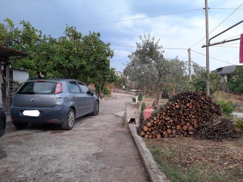 samochód zaparkowany obok stosu drewna opałowego w obiekcie G&M Holiday Home 2 w mieście Minturno