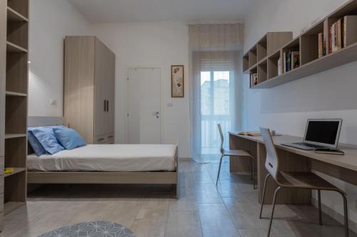 una camera con letto e scrivania con computer portatile di La Casetta di Dado by Wonderful Italy a Torino
