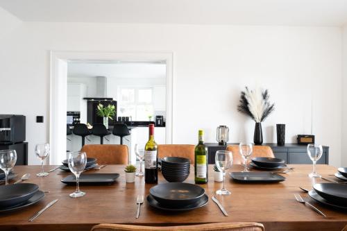 a dining room table with wine bottles and glasses at Escape Ordinary at Lily's Pad in Enniskillen