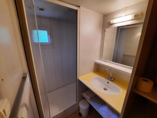 La salle de bains est pourvue d'un lavabo et d'une douche. dans l'établissement Résidence Les Chalets de Millau, à Millau