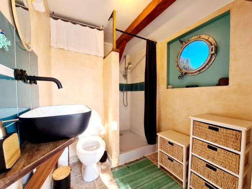 ein Badezimmer mit einem Waschbecken, einem WC und einer Badewanne in der Unterkunft La Roulotte du Coustal, Cajarc, Lot in Cajarc