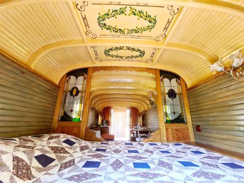 een slaapkamer met een groot bed en een plafond bij La Roulotte du Coustal, Cajarc, Lot in Cajarc