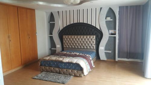 1 dormitorio con 1 cama con cabecero grande en Somptueuse villa à tamaris, en Casablanca