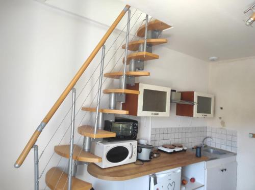 a spiral staircase in a kitchen with a microwave at Studio rénové avec goût in Poitiers