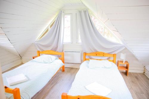 a bedroom with two beds in a attic at Les Cabanes Parisiennes - Chalets 1h30 from Paris - 62P in Sainte-Geneviève-des-Bois