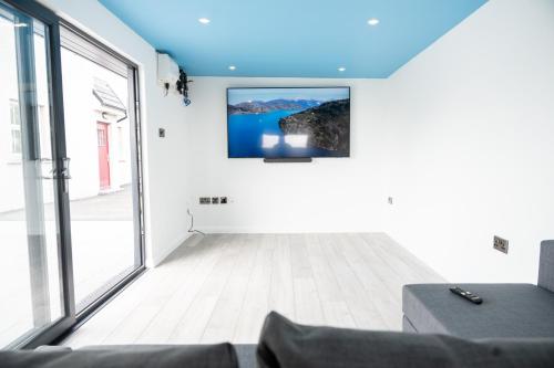 a living room with a tv on the wall at Escape Ordinary at Lily's Pad in Enniskillen