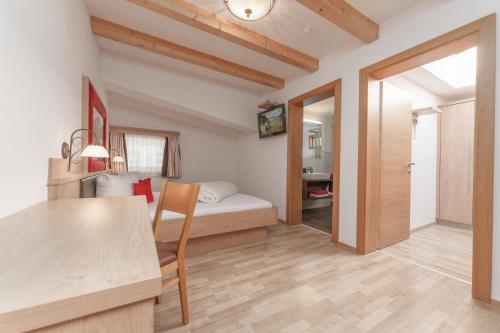 Habitación pequeña con cama y mesa de comedor. en Appartement Oskar, en Sölden