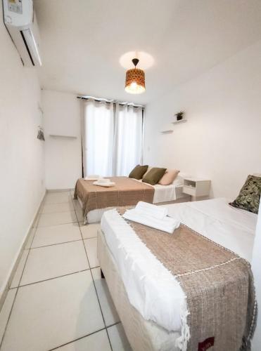 een hotelkamer met 2 bedden en een bank bij Casa com vista mar in Pipa