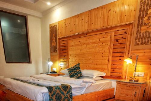 two beds in a room with a wooden wall at Hotel Zion in Leh